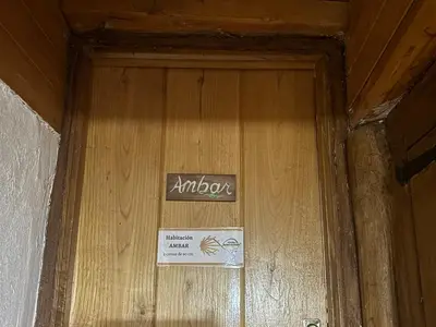 a wooden door with a sign on it at Albergue Rectoral de Romean in Lugo