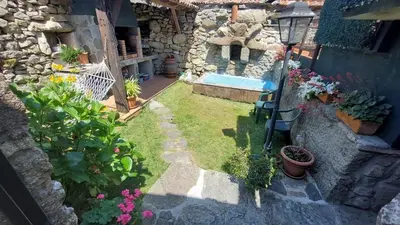 an outdoor garden with a swimming pool and flowers at Casa de pueblo en Galicia, A Forneira in Leiro