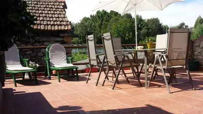 a table and chairs and an umbrella on a patio at Casa de pueblo en Galicia, A Forneira in Leiro