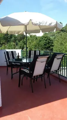a table and chairs under an umbrella on a patio at Casa de pueblo en Galicia, A Forneira in Leiro