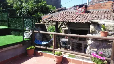 a balcony with a bird cage and potted plants at Casa de pueblo en Galicia, A Forneira in Leiro