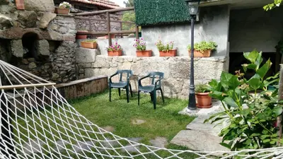a couple of chairs sitting on the grass in a yard at Casa de pueblo en Galicia, A Forneira in Leiro