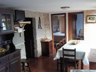 a kitchen and dining room with a table and chairs at Casa de pueblo en Galicia, A Forneira in Leiro