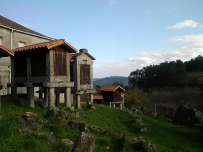 an old house on top of a green field at Casa de pueblo en Galicia, A Forneira in Leiro