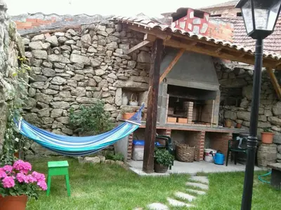 a hammock in front of a stone house at Casa de pueblo en Galicia, A Forneira in Leiro