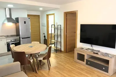 a living room with a table and a large television at Destino Deluxe Mariña in Viveiro