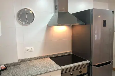 a kitchen with a clock on the wall above a counter at Destino Deluxe Mariña in Viveiro