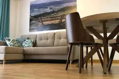 a living room with a couch and a wooden chair at Destino Deluxe Mariña in Viveiro