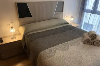 a bedroom with a bed with towels on it at Destino Deluxe Mariña in Viveiro