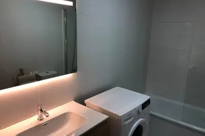 a bathroom with a sink and a washing machine at Destino Deluxe Mariña in Viveiro