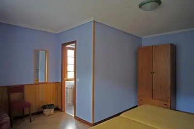 a bedroom with blue walls and a bed and a cabinet at La Rectoral de San Juan in El Franco