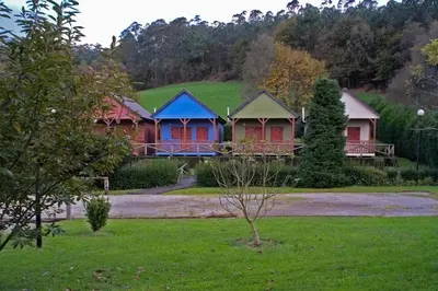 a row of houses in a yard with grass at La Rectoral de San Juan in El Franco