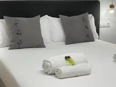 a white bed with towels on it with pillows at Oktheway Pedro Saco Street in Sarria