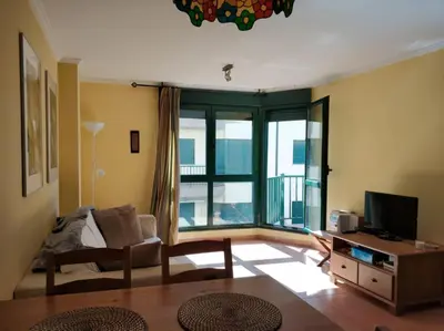 a living room with a couch and a large window at Apartamento Playa Catedrales in Barreiros