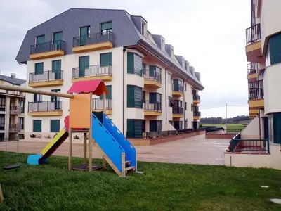 a playground in front of a apartment building at Apartamento Playa Catedrales in Barreiros
