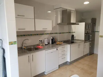 a kitchen with white cabinets and a sink at Slow House Sarria in Sarria