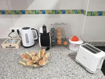 a kitchen counter with a toaster and a plate of food at Slow House Sarria in Sarria