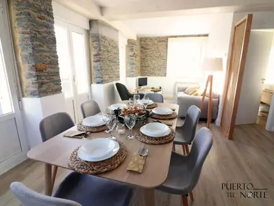 a dining room with a wooden table and chairs at Apartamentos Puerto Norte - Apto 2 in Puerto de Vega