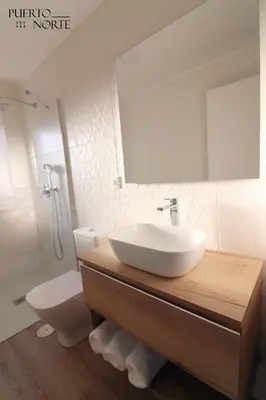a bathroom with a sink and a toilet and a mirror at Apartamentos Puerto Norte - Apto 2 in Puerto de Vega