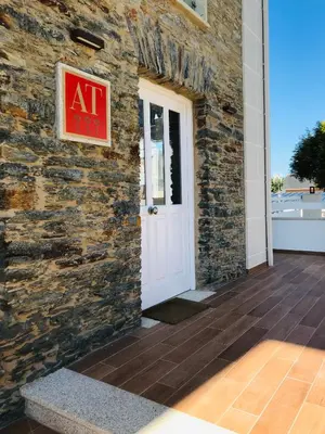 a brick building with a white door and a sign on it at Apartamentos Puerto Norte - Apto 2 in Puerto de Vega