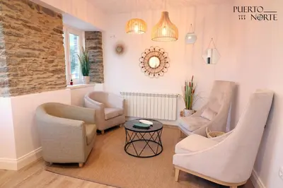 a living room with two chairs and a table at Apartamentos Puerto Norte - Apto 2 in Puerto de Vega
