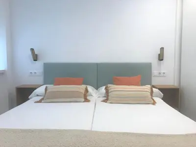 a bedroom with a white bed with two pillows at Apartamentos Puerto Norte - Apto 3 in Puerto de Vega
