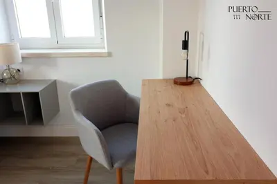 a chair and a wooden table in a room at Apartamentos Puerto Norte - Apto 3 in Puerto de Vega