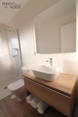 a bathroom with a sink and a toilet and a mirror at Apartamentos Puerto Norte - Apto 3 in Puerto de Vega