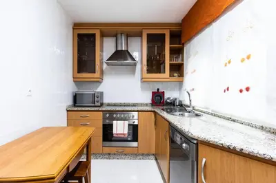 a kitchen with wooden cabinets and a wooden table at APARTAMENTO EN A ESTRADA/GALICIA in A Estrada