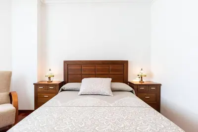 a bedroom with a bed with two night stands and two lamps at APARTAMENTO EN A ESTRADA/GALICIA in A Estrada