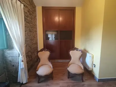 two chairs sitting in a hallway next to a door at Casa Rural A Eira Vella in Padrón