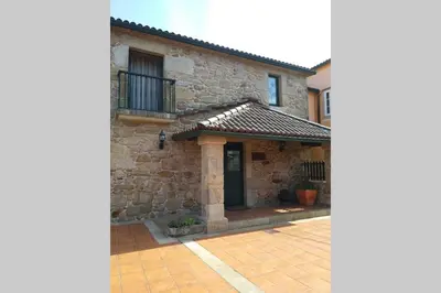 a stone house with a door and a porch at Casa Rural A Eira Vella in Padrón