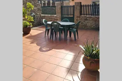 a patio with a table and chairs on a patio at Casa Rural A Eira Vella in Padrón