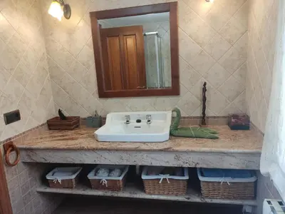 a bathroom with a sink and a mirror and baskets at Casa Rural A Eira Vella in Padrón
