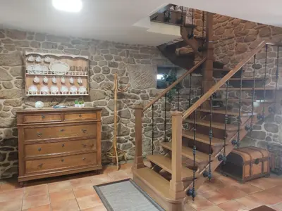 a staircase in a room with a stone wall at Casa Rural A Eira Vella in Padrón
