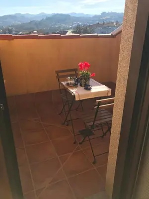 a table with a vase of flowers on a balcony at APARTAMENTO MANUEL MARIA in Allariz