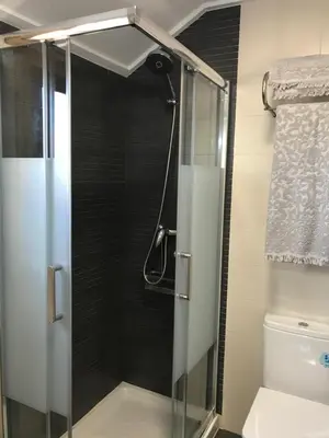 a shower with a glass door in a bathroom at APARTAMENTO MANUEL MARIA in Allariz