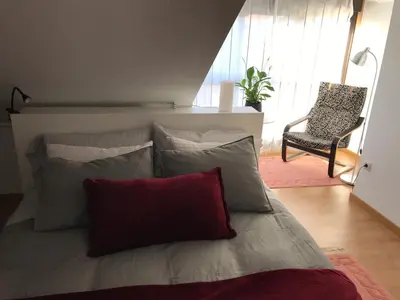 a bed with pillows and a chair in a room at APARTAMENTO MANUEL MARIA in Allariz