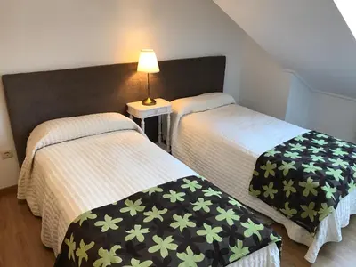 two twin beds in a room with a lamp at APARTAMENTO MANUEL MARIA in Allariz