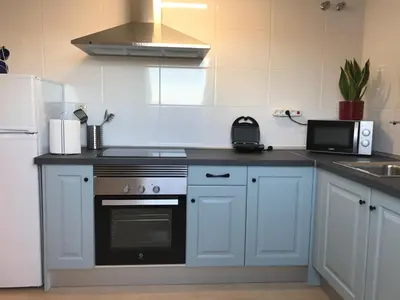 a kitchen with a stove and a microwave at APARTAMENTO MANUEL MARIA in Allariz