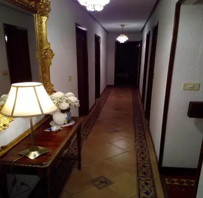 a hallway with a table with a lamp and a mirror at Casa independiente para grandes grupos y familias in Valeije