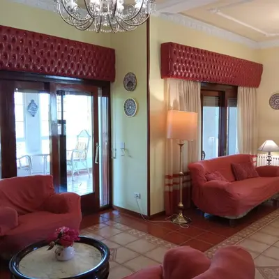 a living room with red furniture and a chandelier at Casa independiente para grandes grupos y familias in Valeije