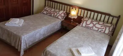 a bedroom with two beds and a table with towels at Casa independiente para grandes grupos y familias in Valeije
