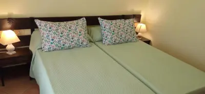a bedroom with a bed with two pillows and two lamps at Casa independiente para grandes grupos y familias in Valeije