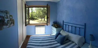 a blue bedroom with a bed and a window at A PORTELA - Pereiro de Aguiar in Covas
