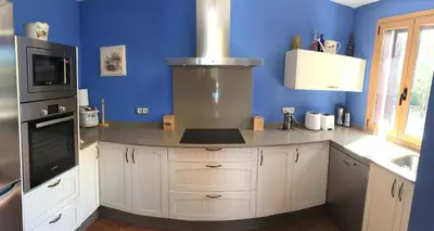 a kitchen with white cabinets and a blue wall at A PORTELA - Pereiro de Aguiar in Covas