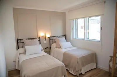 a bedroom with two beds and a window at Pension Casa Manolo in Fonsagrada