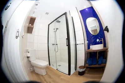 a bathroom with a toilet and a glass shower at Pension Casa Manolo in Fonsagrada
