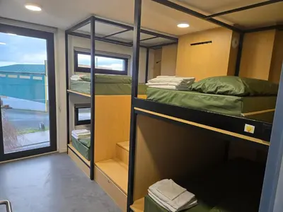 a room with three bunk beds and a window at Los Tres Abetos in Arzúa