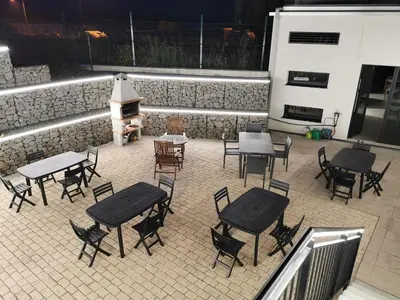 a patio with tables and chairs and a grill at Los Tres Abetos in Arzúa